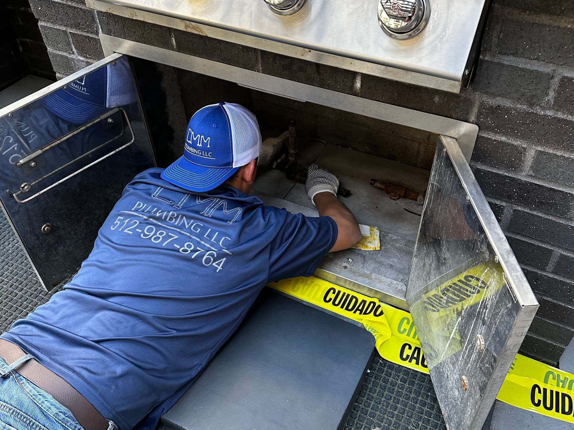 a man in a blue shirt is working on a fireplace .