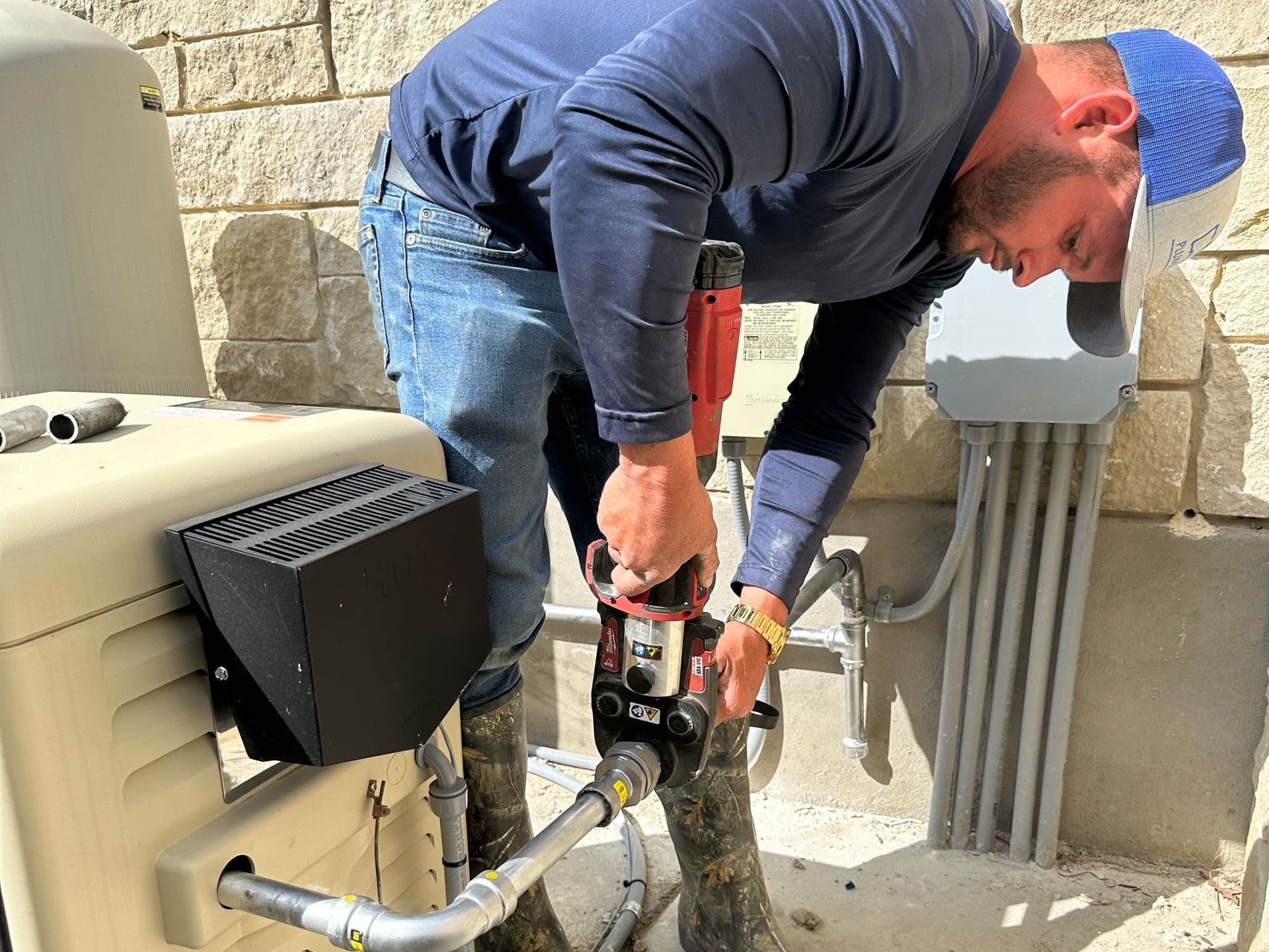 CMM Plumbing technician working on a gas pipe with a drill