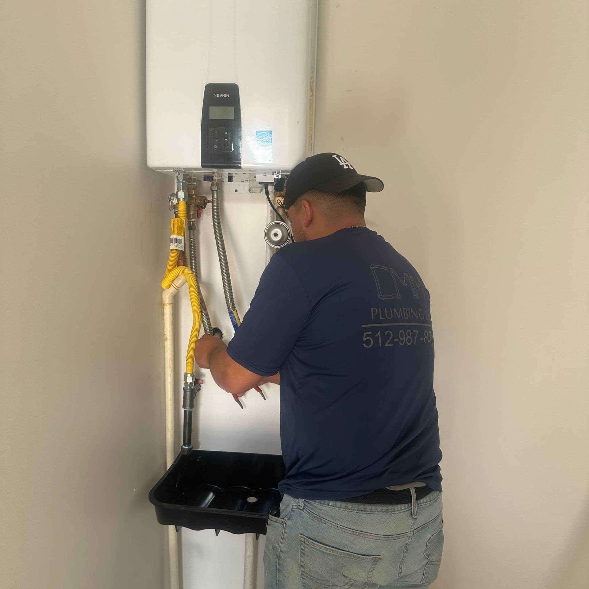 CMM Plumbing technician working on a water heater