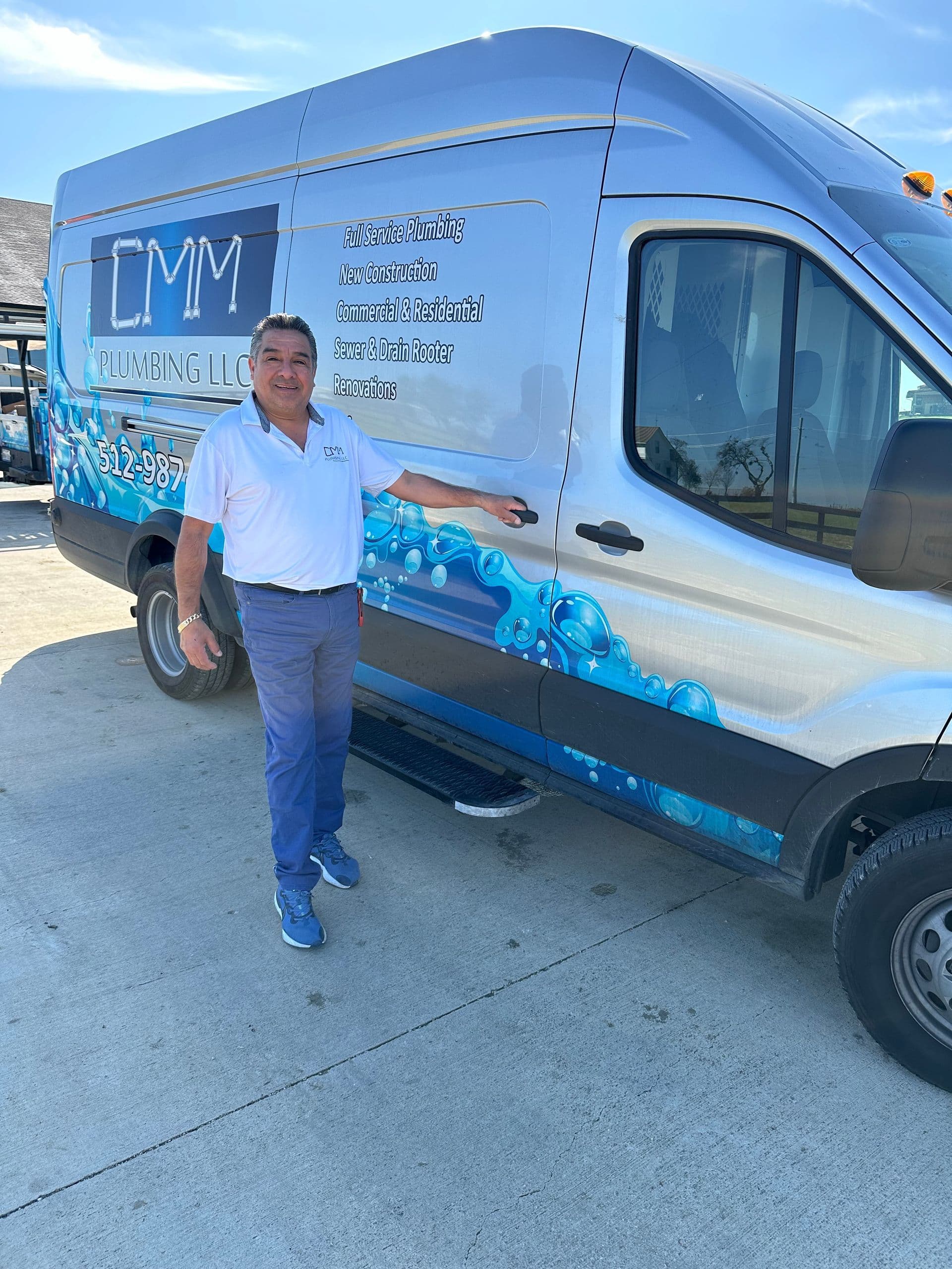 Manny of CMM Plumbing standing beside the company service van