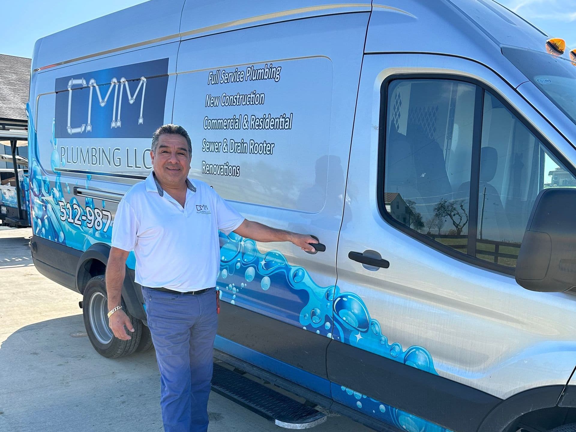 CMM Plumbing owner standing next to the company service van