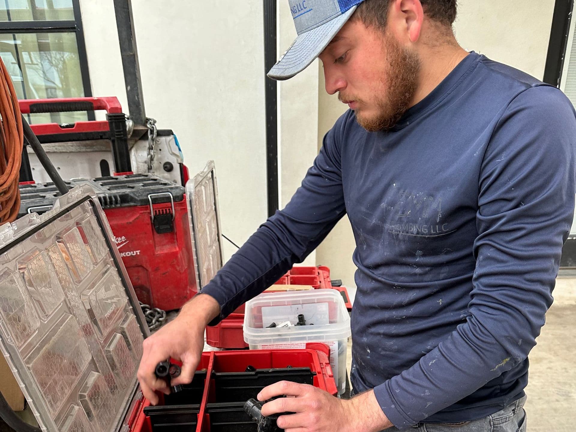 CMM Plumbing technician organizing tools and parts on a job site