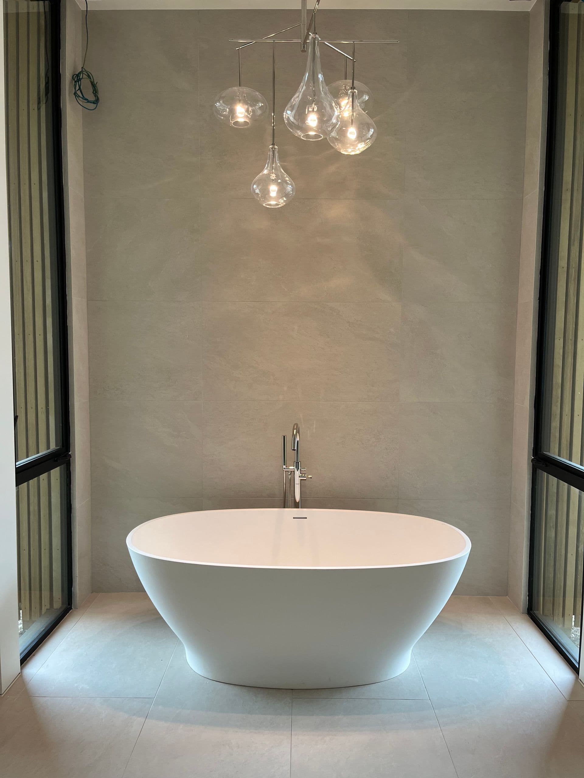 a bathroom with a bathtub and a chandelier hanging from the ceiling .