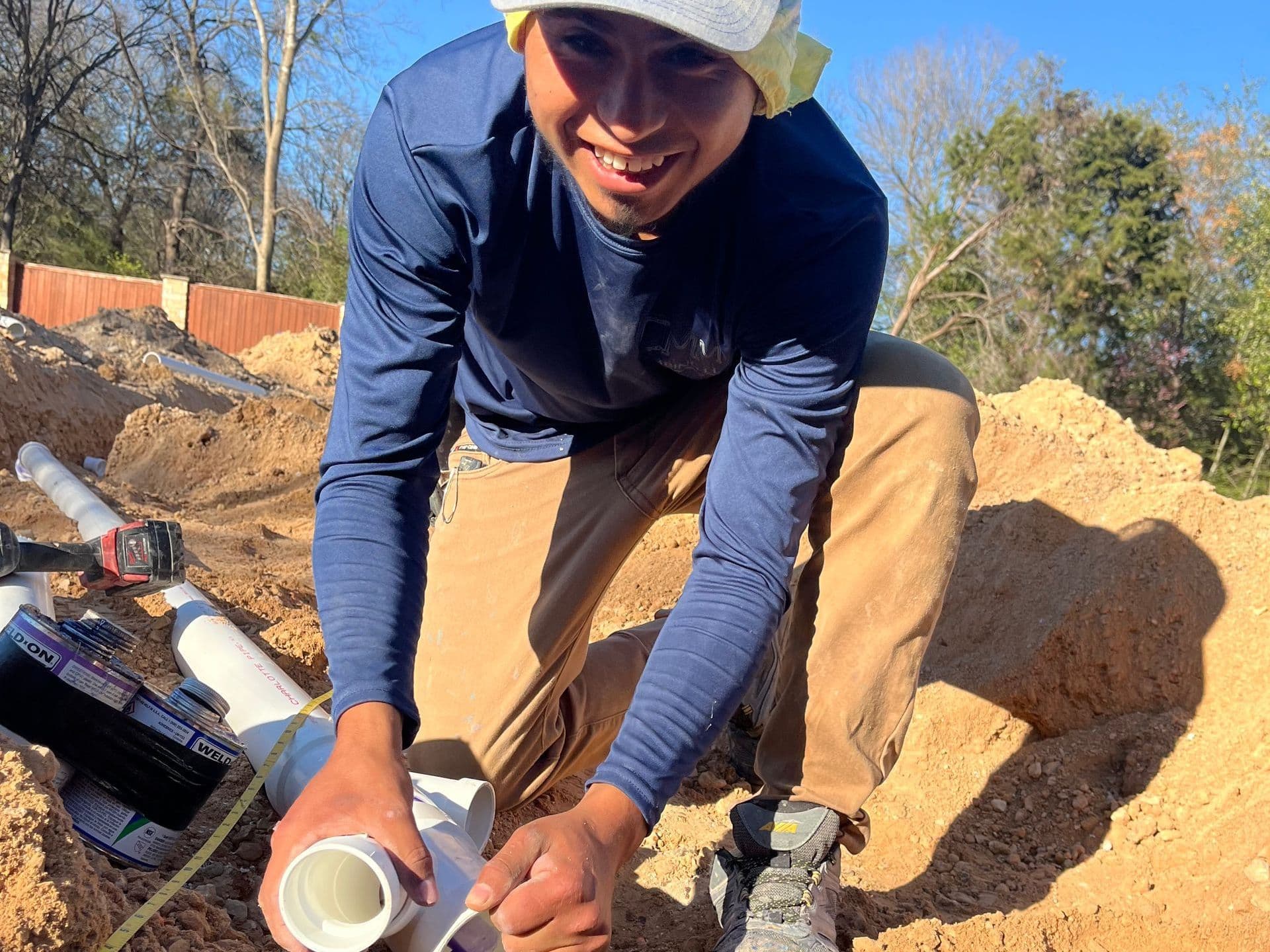 CMM Plumbing technician smiling while installing new construction plumbing