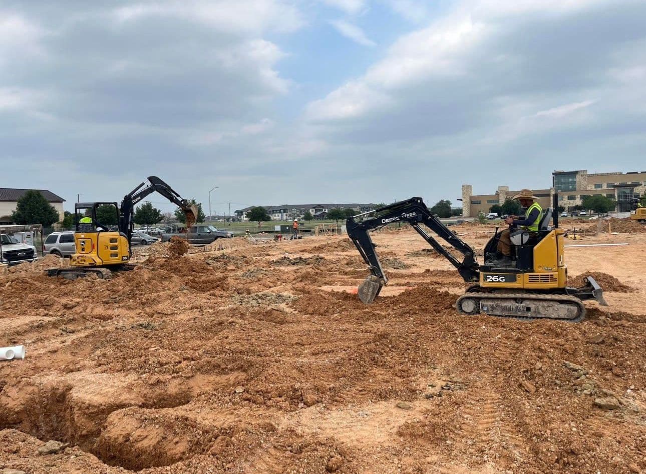 CMM Plumbing crew operating equipment on a commercial job site