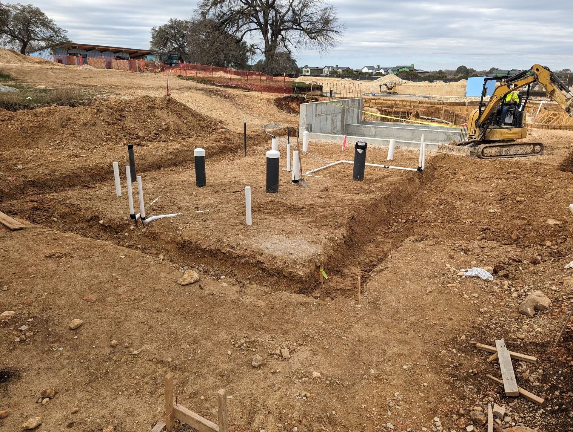 a construction site with a lot of dirt and pipes in it .