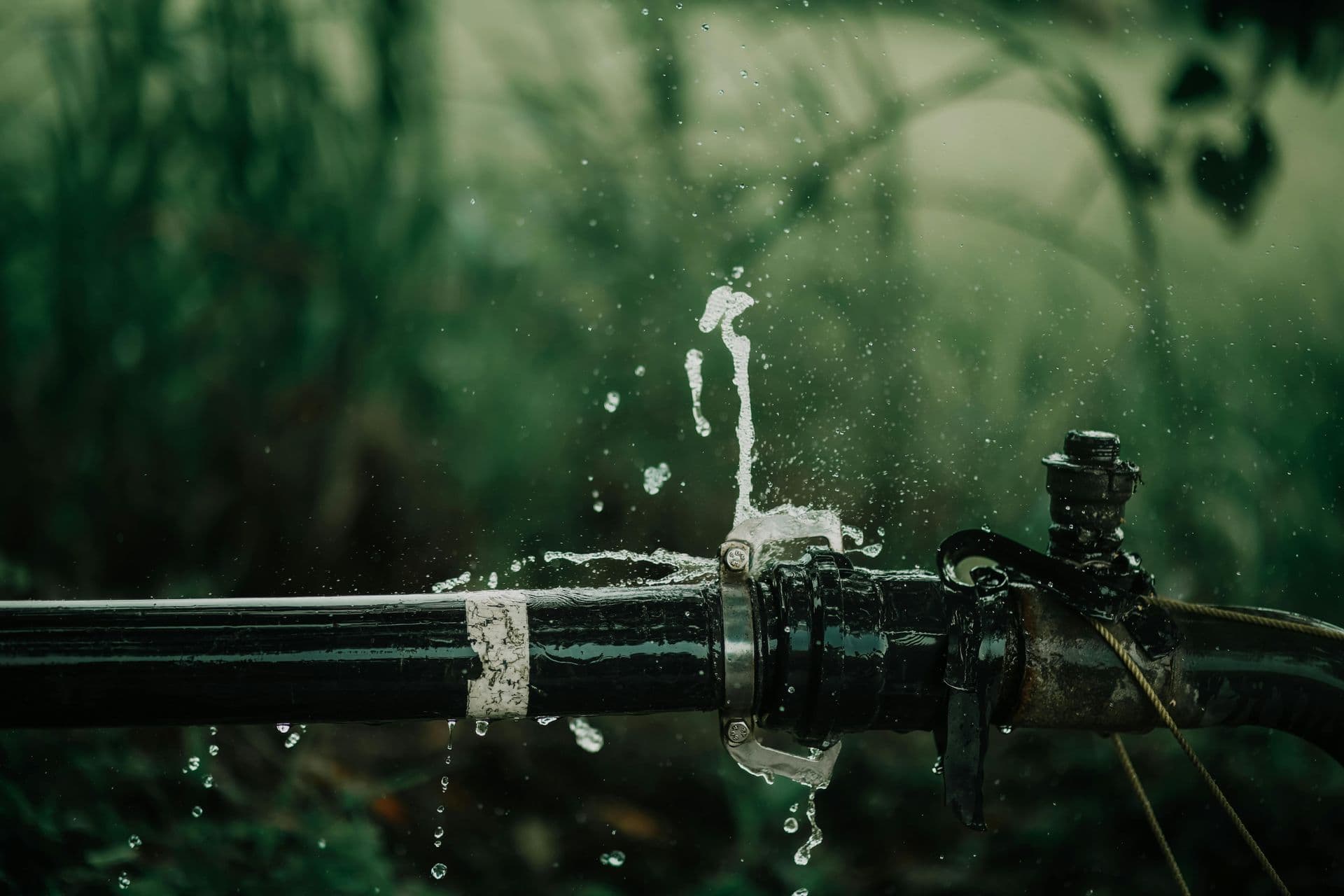 A burst pipe is spraying water outdoors, requiring an emergency plumber in Coupland, TX.