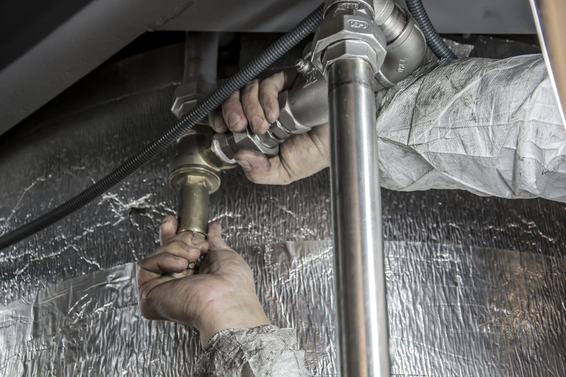 Plumber installing energy-efficient water heater as part of plumbing energy efficiency upgrades